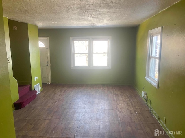 170 Rutgers St, New Brunswick, NJ 08901 - spare room featuring a textured ceiling, healthy amount of natural light, hardwood / wood-style floors, stairway, and baseboards