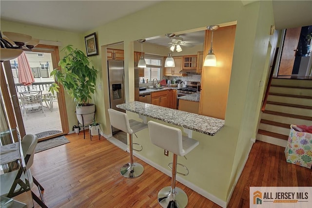 182 Columbia Ave, North Plainfield, NJ 07060 - kitchen with wood finished floors, a ceiling fan, glass insert cabinets, a sink, and baseboards