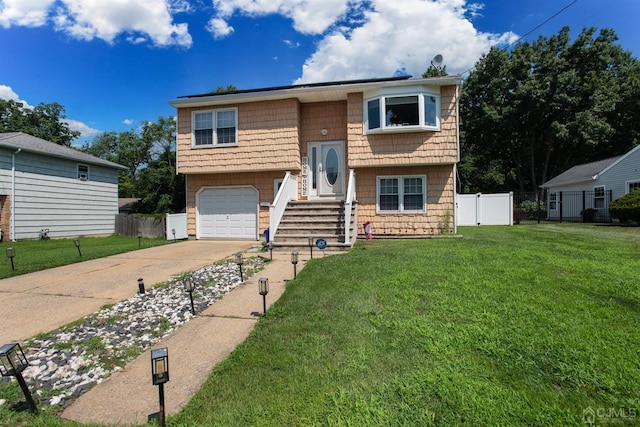 raised ranch with a front yard and a garage