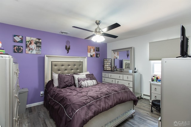 bedroom with ceiling fan, dark wood-type flooring, and a baseboard radiator