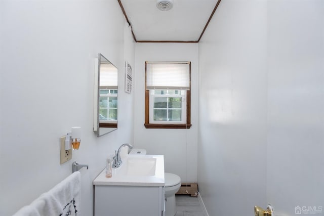 bathroom featuring toilet, baseboard heating, and vanity