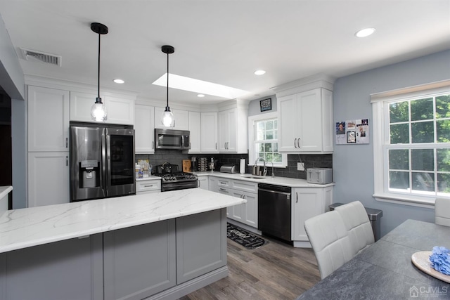 kitchen with sink, white cabinetry, pendant lighting, and black appliances