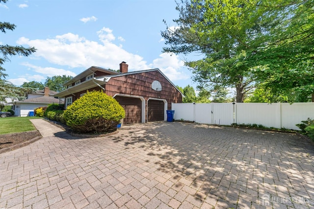 85 Hidden Lake Dr, North Brunswick, NJ 08902 - view of property exterior featuring a gate, a chimney, a garage, and decorative driveway