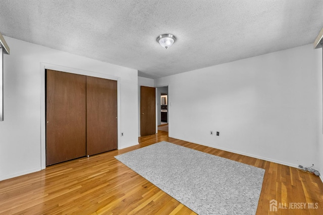 85 Hidden Lake Dr, North Brunswick, NJ 08902 - unfurnished bedroom with a textured ceiling, a closet, and light wood finished floors