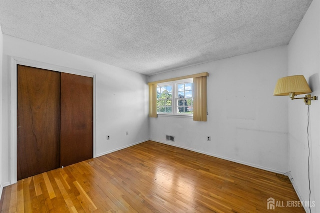 85 Hidden Lake Dr, North Brunswick, NJ 08902 - unfurnished bedroom featuring hardwood / wood-style flooring, a textured ceiling, and a closet