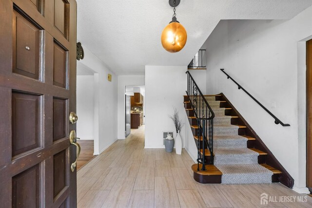 85 Hidden Lake Dr, North Brunswick, NJ 08902 - foyer with stairway, light wood-style floors, and a textured ceiling