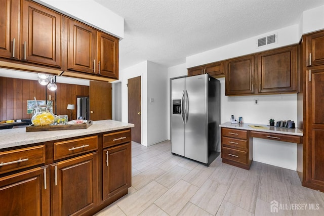 85 Hidden Lake Dr, North Brunswick, NJ 08902 - kitchen with stainless steel refrigerator with ice dispenser, built in study area, a textured ceiling, and light stone counters
