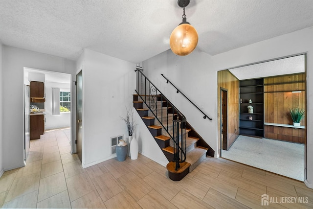 85 Hidden Lake Dr, North Brunswick, NJ 08902 - stairs with a textured ceiling, built in features, and wood finished floors
