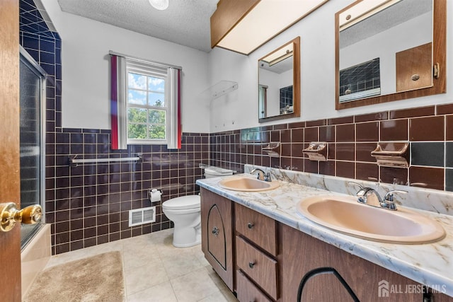 85 Hidden Lake Dr, North Brunswick, NJ 08902 - bathroom with tile walls, tile patterned floors, a textured ceiling, double vanity, and a wainscoted wall