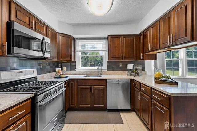 85 Hidden Lake Dr, North Brunswick, NJ 08902 - kitchen with stainless steel appliances, plenty of natural light, a textured ceiling, decorative backsplash, and a peninsula