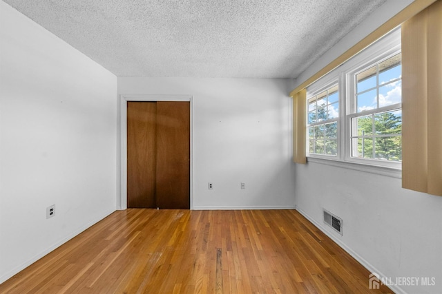 85 Hidden Lake Dr, North Brunswick, NJ 08902 - spare room with a textured ceiling and light wood-style flooring