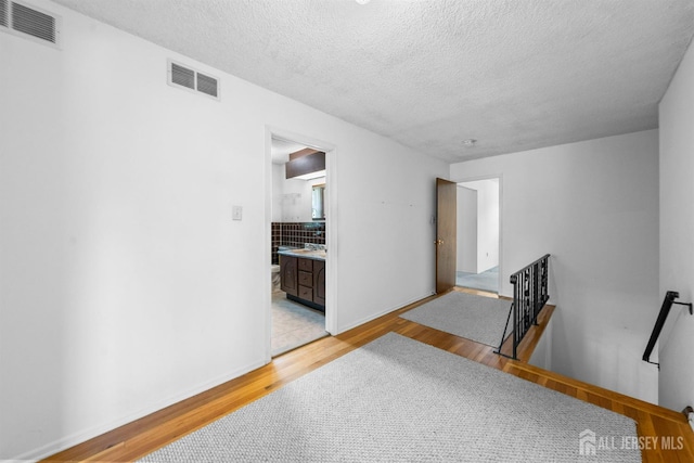 85 Hidden Lake Dr, North Brunswick, NJ 08902 - empty room with light wood-style flooring and a textured ceiling