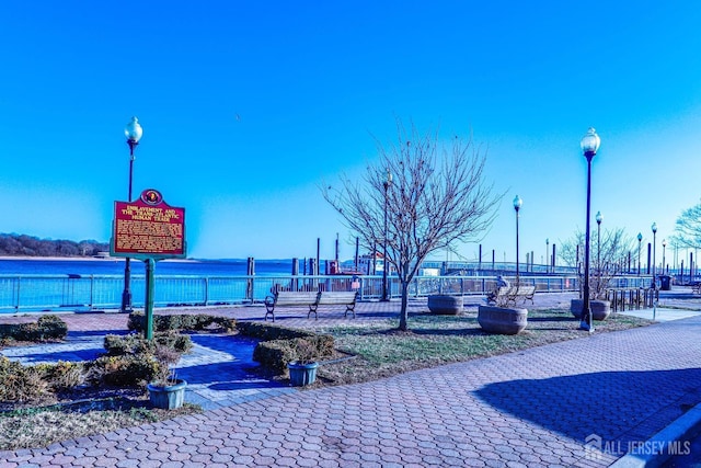 view of property's community featuring a water view and fence