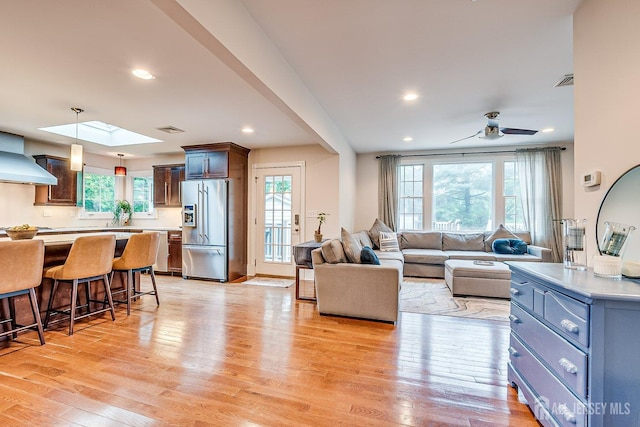 living area with plenty of natural light, light wood-type flooring, recessed lighting, and a ceiling fan