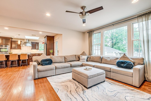living area featuring light wood-type flooring, ceiling fan, and recessed lighting