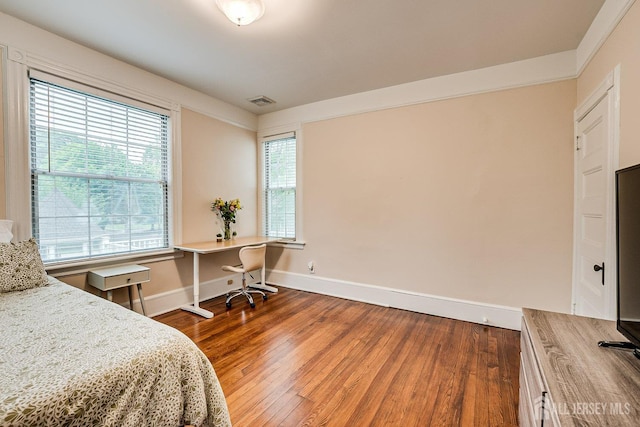 bedroom with baseboards, wood finished floors, and a desk