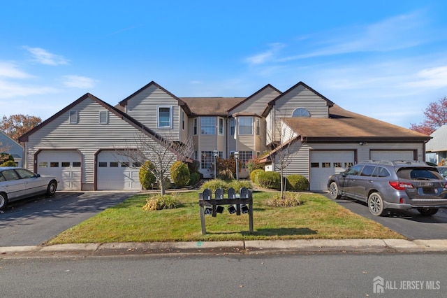 view of front of property with aphalt driveway, a front lawn, and an attached garage