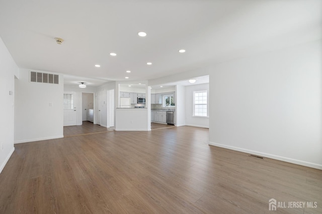 unfurnished living room featuring visible vents, wood finished floors, and recessed lighting