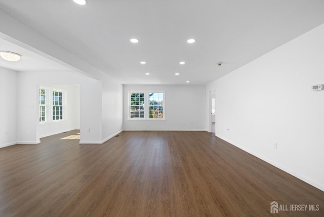 unfurnished living room featuring recessed lighting, dark wood finished floors, and baseboards