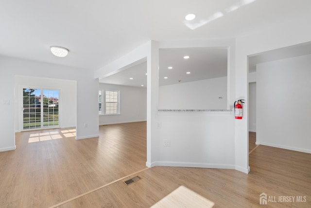 unfurnished room with baseboards, visible vents, wood finished floors, and recessed lighting