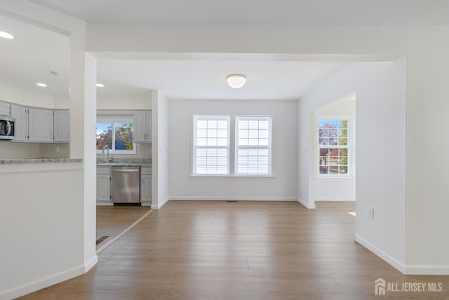 interior space featuring light wood-type flooring, baseboards, and a sink