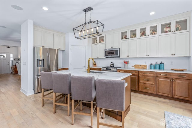 85 Valentino Dr, Old Bridge, NJ 08875 - kitchen featuring stainless steel appliances, light wood-style flooring, a kitchen breakfast bar, decorative light fixtures, and light stone countertops