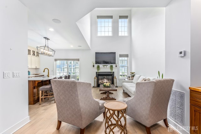 85 Valentino Dr, Old Bridge, NJ 08875 - living area featuring light wood finished floors, a glass covered fireplace, recessed lighting, and a chandelier