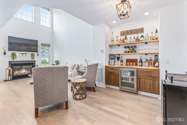 85 Valentino Dr, Old Bridge, NJ 08875 - indoor dry bar with wine cooler, light wood-style flooring, healthy amount of natural light, a glass covered fireplace, and recessed lighting