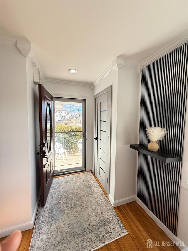 entrance foyer with ornamental molding and light hardwood / wood-style flooring