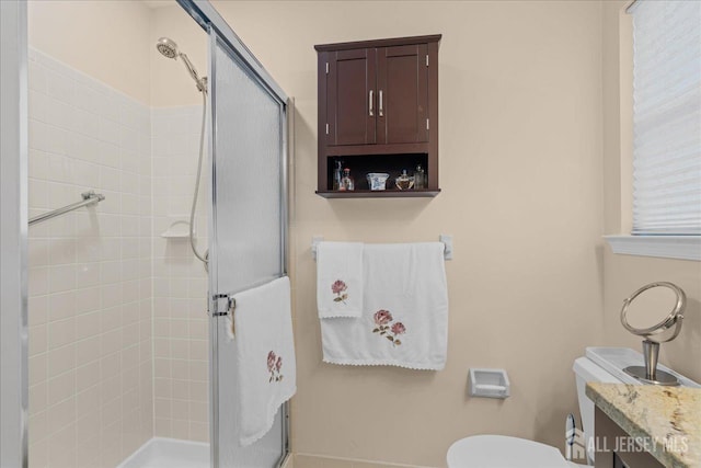 bathroom featuring an enclosed shower and toilet