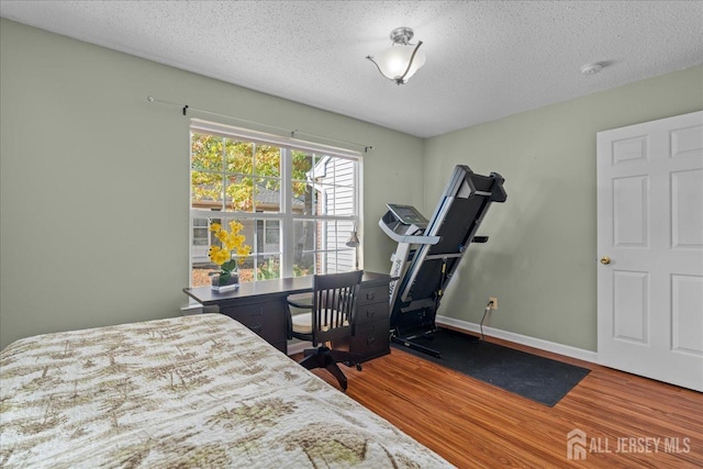 bedroom with wood-type flooring and a textured ceiling