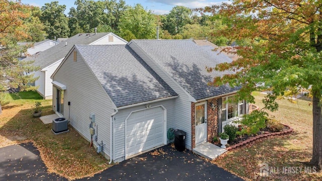 view of front facade featuring a garage and cooling unit