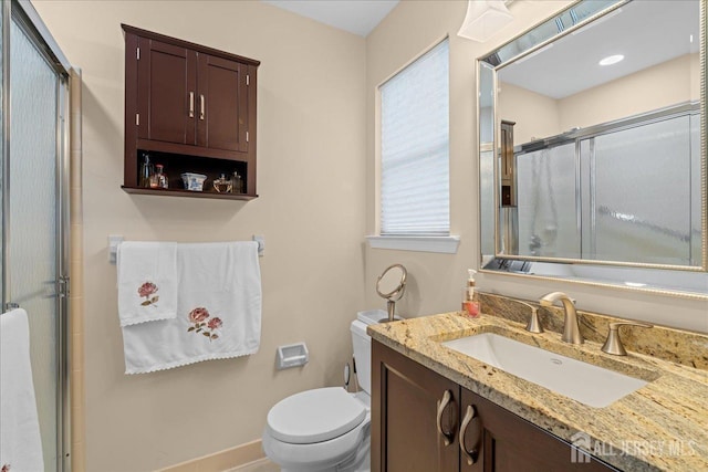 bathroom featuring vanity, toilet, and walk in shower