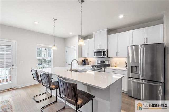 1604 English Ln, Sayreville, NJ 08859 - kitchen with appliances with stainless steel finishes, light countertops, light wood-type flooring, white cabinets, and recessed lighting