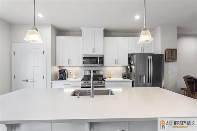 1604 English Ln, Sayreville, NJ 08859 - kitchen featuring appliances with stainless steel finishes, a center island with sink, backsplash, light countertops, and white cabinetry