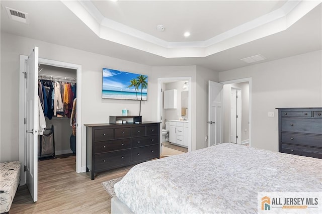 1604 English Ln, Sayreville, NJ 08859 - bedroom featuring a raised ceiling, a spacious closet, light wood-style flooring, a closet, and connected bathroom