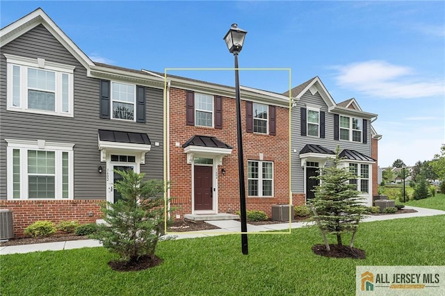 1604 English Ln, Sayreville, NJ 08859 - view of property featuring brick siding, a front yard, a standing seam roof, and a metal roof
