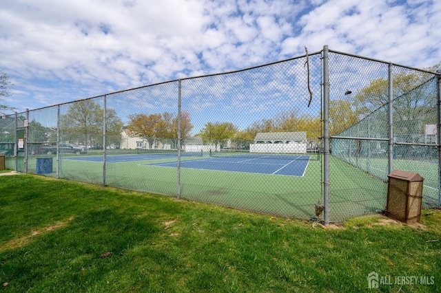 view of tennis court with a lawn