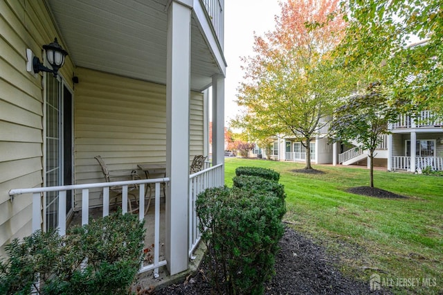 view of property exterior featuring a porch and a yard