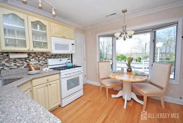 107 N Edward St, Sayreville, NJ 08872 - kitchen with white appliances, cream cabinets, a chandelier, light wood-type flooring, and light countertops