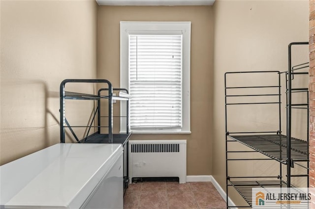 washroom featuring radiator heating unit, baseboards, and tile patterned flooring