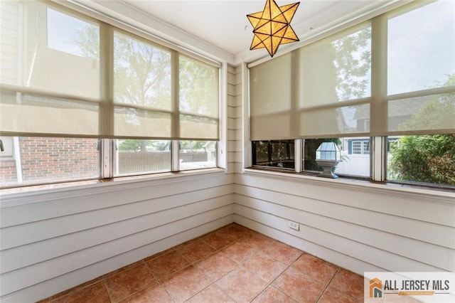 unfurnished sunroom featuring tile patterned floors