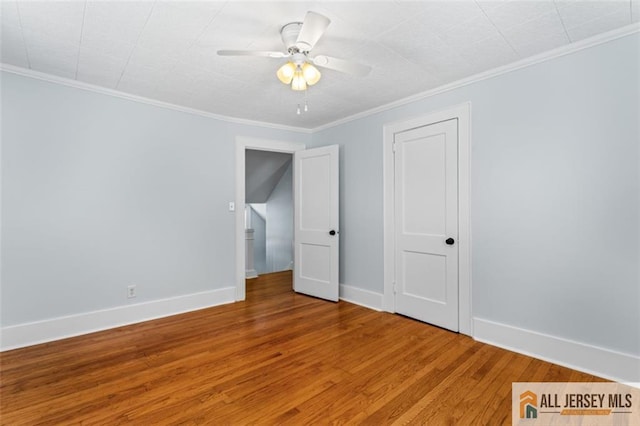 unfurnished room with wood finished floors, baseboards, ornamental molding, and ceiling fan
