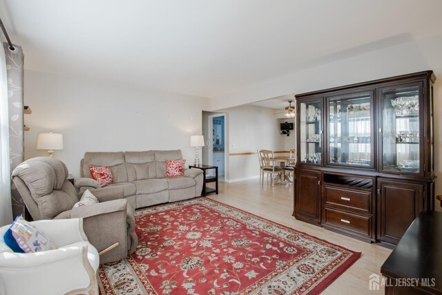 living room featuring ceiling fan and light hardwood / wood-style floors