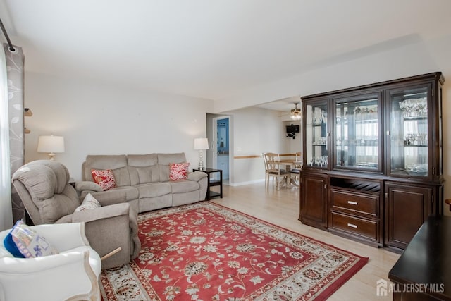 living area featuring baseboards and light wood-type flooring