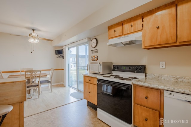 kitchen with ceiling fan, light stone counters, and white appliances