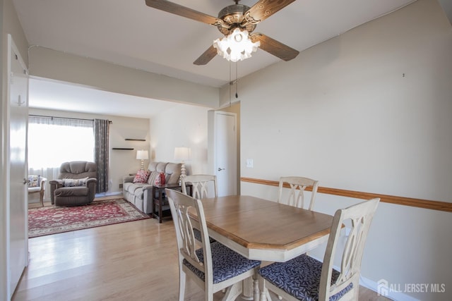 dining space with light wood finished floors and ceiling fan