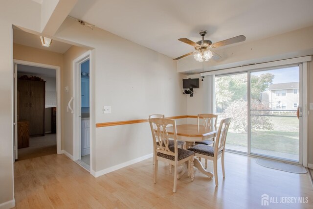 dining space with light wood-type flooring and ceiling fan