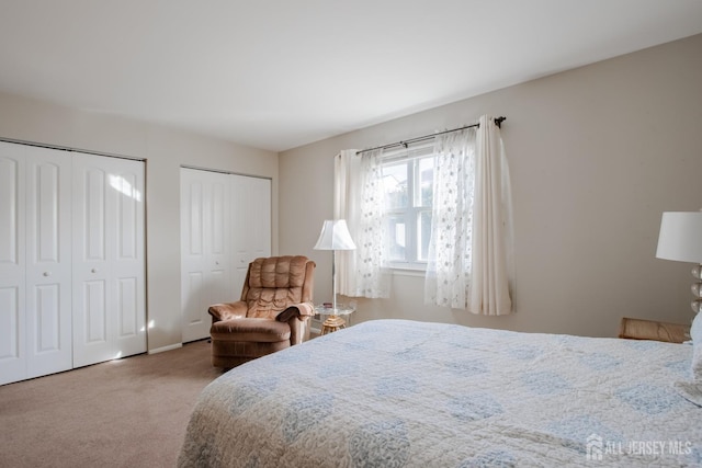 carpeted bedroom featuring two closets