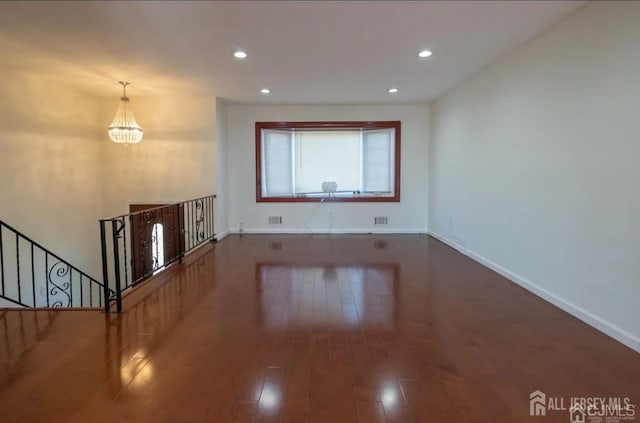 unfurnished living room featuring recessed lighting, dark wood-style flooring, visible vents, and baseboards